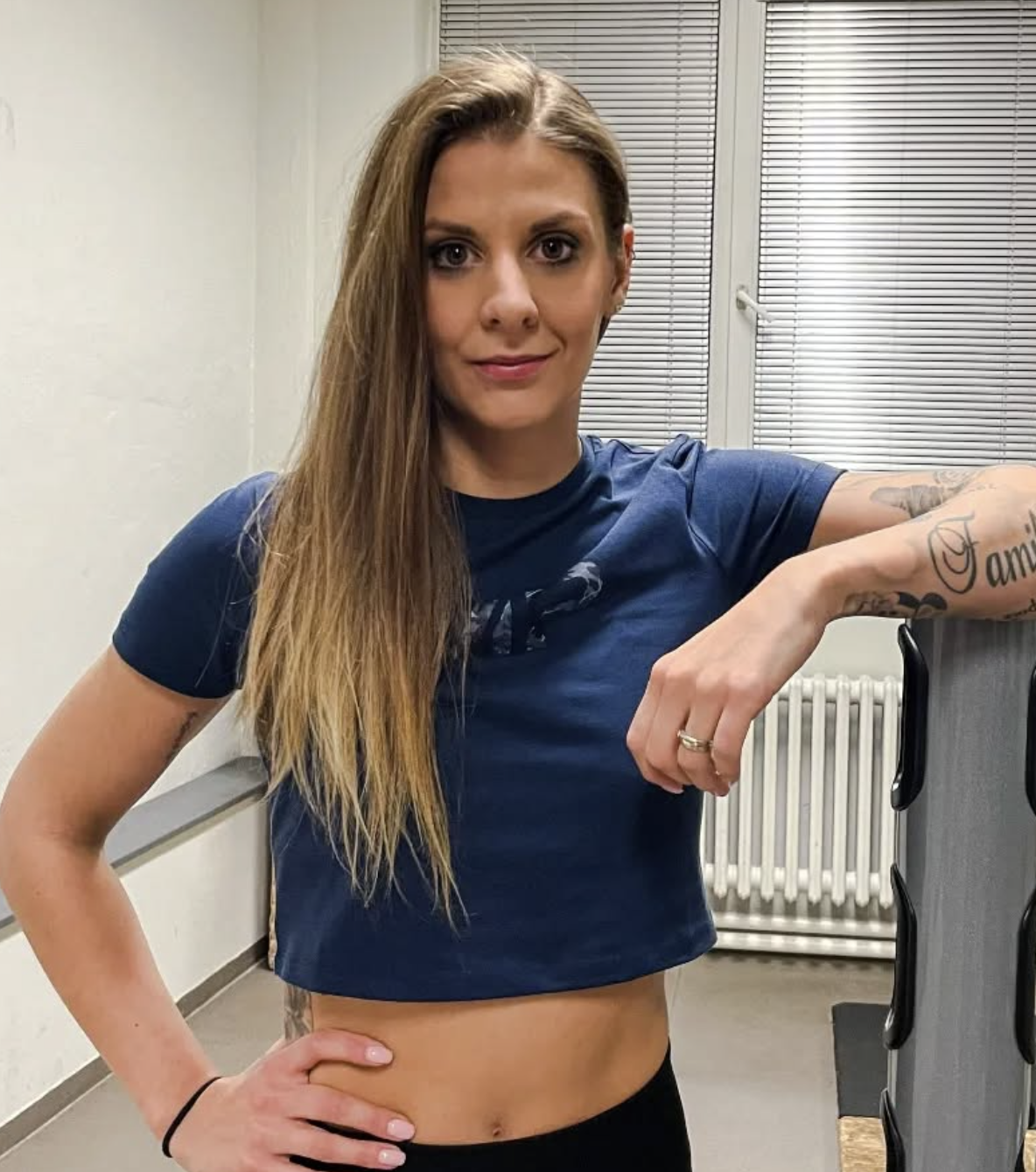 Žena v modrém tričku v posilovně